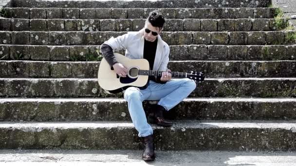 Hombre tocando la guitarra acustica al aire libre — Vídeo de stock