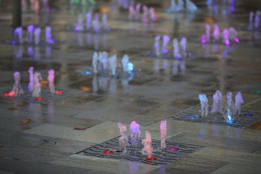 Dansçı Çeşmeler 'in manzarası. Gece meydanında bir grup küçük renkli şelale. Arka plan görüntüsü.