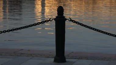 Suda gün batımı. Gece dalgası dalgalanması. Güneşin yansımasının altın su dalgalarında yansıması. Huzurlu bir arka plan.