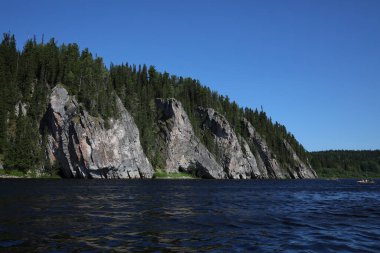 Eşsiz doğal manzara dağları. Üzerinde orman olan kayalar. Suda büyük bir uçurum. Taştan bir kaya. Aktif yaz turizmi kavramı.
