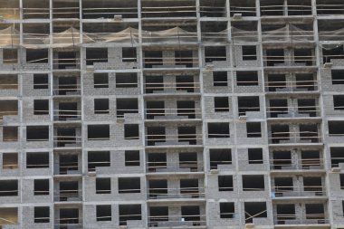 Yeni bir ev inşaatı. Cam olmayan gri betondan yapılmış bir binanın imajı. Geliştirme ve konut tedariği kavramı.
