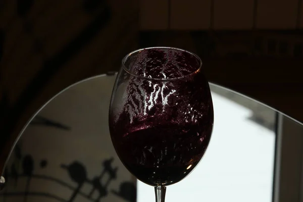 Image of a dirty glass with prints of juice pulp on the walls close-up.The concept of the end of a party or dinner.Shaded abstract background