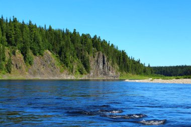 Gölün kayalık kıyıları orman ve gökyüzünün renginden gelen mavi suyla kaplıydı ve yarıkların üzerinde küçük bir dalga vardı. Güzel vahşi yaşam manzarası
