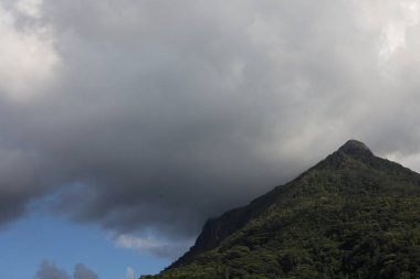 Dağların üzerindeki bulutlar. Zirvenin üstündeki kasvetli gökyüzü tropikal doğa manzarası. Arka plan.