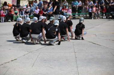 Spor üniformalı bir grup genç kız okul bahçesinde beyzbol şapkası takıyor takım yarışmasında maç izleyen ebeveynler oynuyor.