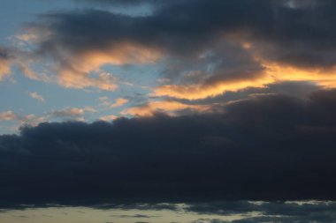 Günbatımı gökyüzü altın parıltısıyla kara bulut