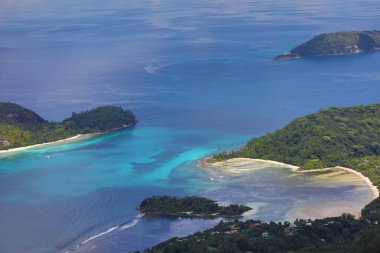 Denizde tropik adanın turkuvaz suyu ve plajlı lagün görüntüsü yukarıdan izleniyor. HDR çekim modu.