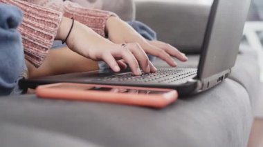 Dizüstü bilgisayarda klavye kullanan bir kadının elleri evde çalışır vaziyette oturup ev bilgisayarı yazılımları uygulamaları teknoloji konseptinde öğrenir, yan görünümü kapatır.