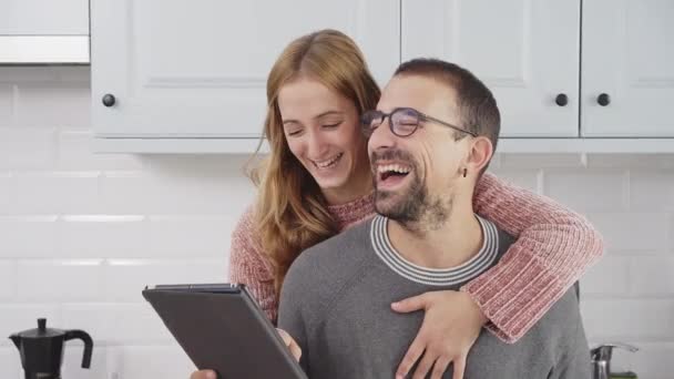 Pareja Leyendo Una Tableta Riendo Cocina Casa — Vídeos de Stock