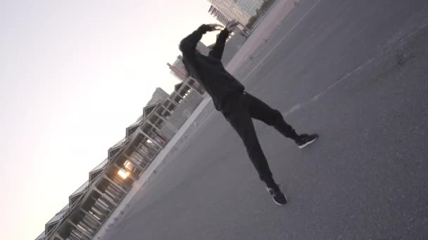 Atletyczny Młodzieniec Czarnych Ciuchach Tańczący Współczesny Miejskim Otoczeniu Robiący Gwiazdy — Wideo stockowe
