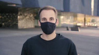 Kameraya bakıyorum. Koronavirüs salgınından dolayı maske takan genç bir İspanyol 'un portresi. Hem elbiseler hem de maske siyah..