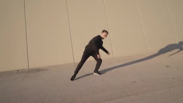 Joven Atlético Vestido Negro Bailando Contemporáneo Frente Una Pared Gris — Vídeos de Stock