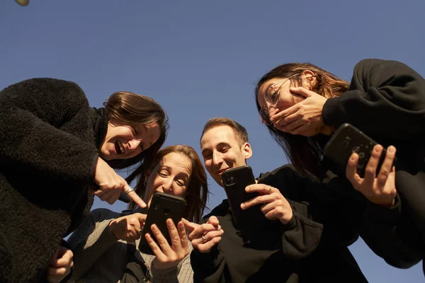 Niski Kąt Grupy Przyjaciół Pomocą Smartfona Śmiechu Uczy Ich Czegoś — Zdjęcie stockowe