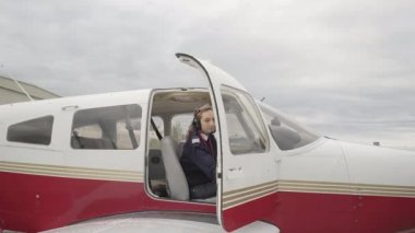 Öğrencisiyle birlikte bir uçuş eğitmeni uçağın içinde kapıları kapatıyor ve uçmaya hazırlanıyor..