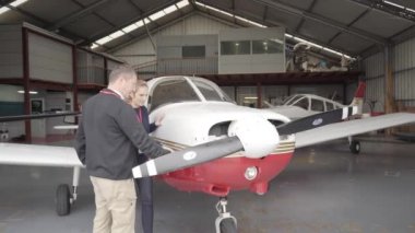 Bayan uçuş eğitmeni öğrencisine uçağın bakımını öğretiyor..