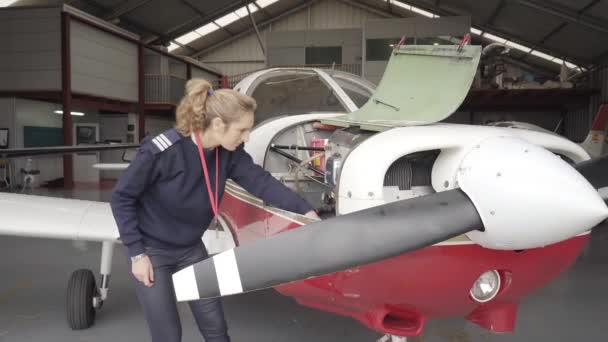 机库里的领航员在维修一架小型飞机的引擎 飞行前准备工作 — 图库视频影像