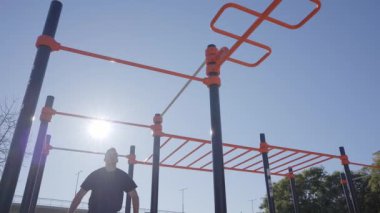 Çıtada egzersiz yapan bir adamın alçak açısı. Açık hava egzersizi. Sağlıklı yaşam, spor, eğitim, beden eğitimi kavramı.