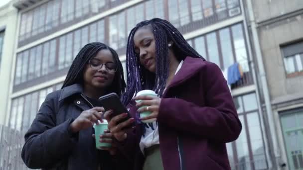 Foto Orbital Duas Jovens Afro Americanas Usando Telefone Segurando Café — Vídeo de Stock