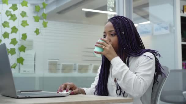Geschäftsfrau Sitzt Schreibtisch Und Trinkt Kaffee Während Sie Laptop Arbeitet — Stockvideo