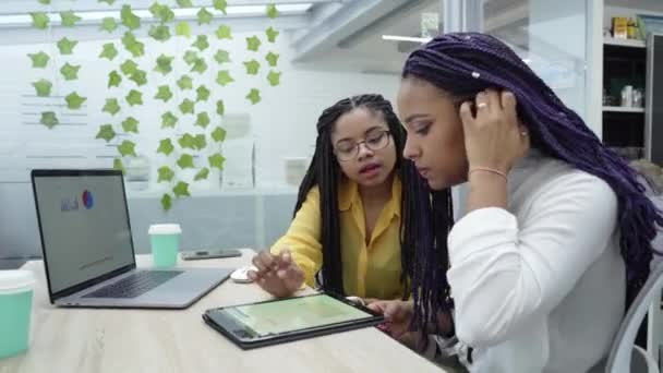 两名年轻的黑人妇女正在审查各种电子设备的分析数据 我在千禧工人的办公室工作 — 图库视频影像