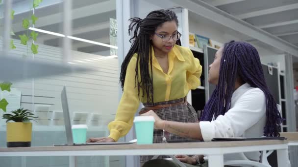 アフリカ系アメリカ人女性の同僚がオフィスミーティングでデジタルマーケティング戦略に関するアイデアを共有 — ストック動画