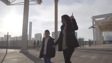 Bekar bir annenin oğluyla parkta yürüyüşünün yörünge fotoğrafı. Oğlu dikkatle dinlerken annesi ona bir şey anlatıyor..