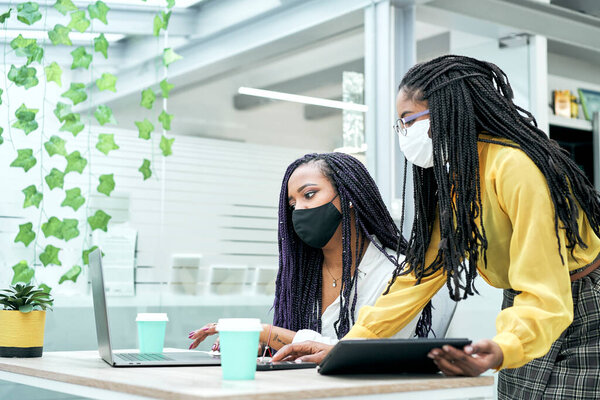 Афроамериканские коллеги говорят о совместной работе, делятся идеями о стратегии цифрового маркетинга на офисном совещании.