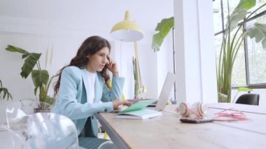 Evde dizüstü bilgisayarla çalışan bir kadın. Modern bir dairede çalışan bir iş kadınının 4K videosu..