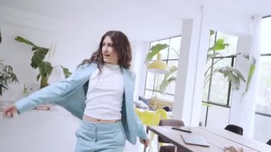 İş kadını ofiste dans ediyor. Komik işçiler, iş bitiminde başarıları kutlarken kaygısız dans ederler..