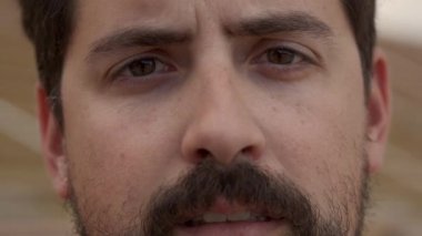 Kameraya ciddi ciddi bakan bir İspanyol 'un açık hava portresi. Genç bir Latin erkeğin yakın plan fotoğrafı. İnsanlar ve duygular kavramı.