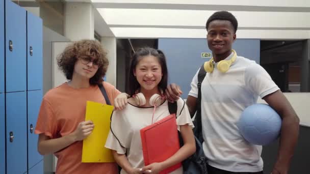 Multikulturális osztálytársak a gimiben. A fiatal tinédzserek vidám mosollyal néznek a kamerába.. — Stock videók