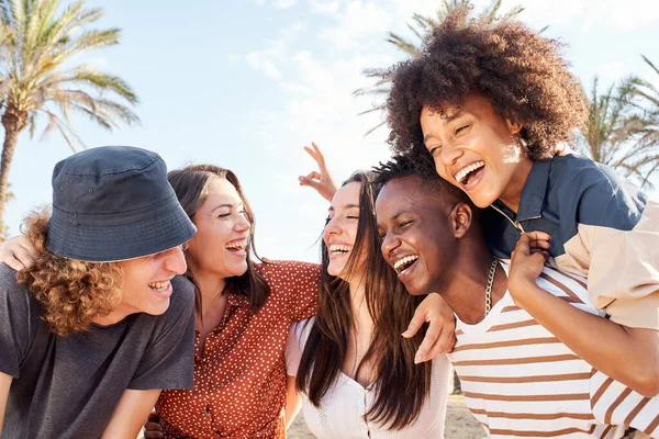 Farklı ırklardan gelen bir grup genç dışarıda gülüp eğleniyor. Tatil kavramı, eğlence, boş zaman, yaz.