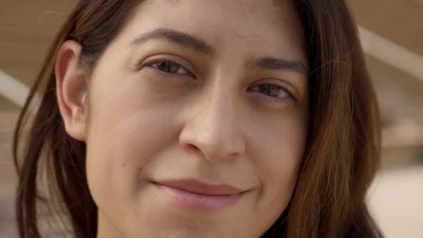 Retrato ao ar livre de uma mulher latina olhando para a câmera sorridente. Close-up de um rosto humano feliz. Conceito de pessoas e emoções. — Vídeo de Stock