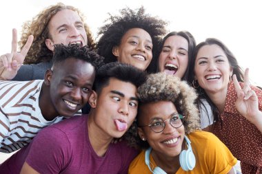 Arkadaşların portresi cep telefonuyla fotoğraf çeker. Çoklu etnik konsept, özçekim, arkadaşlık, aptalı oyna..