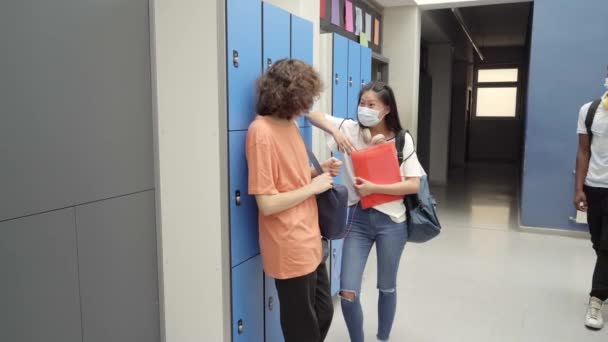 De vuelta a la clase de jóvenes estudiantes que usan máscaras para protegerse de la pandemia del coronavirus. Saludo pandémico. — Vídeos de Stock