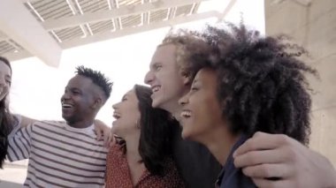 Gülümseyen ve birlikte olmaktan mutlu bir grup insan. Arkadaşlarıyla kucaklaşan Latin bir kız, Afro-Amerikan bir oğlan ve Asyalı bir oğlan. Çok ırklı öğrenci kavramı.