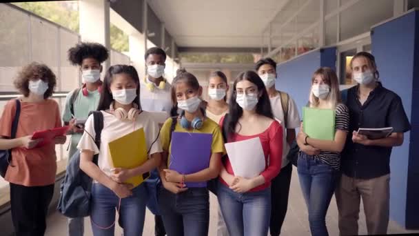 Retrato de un grupo de estudiantes con máscara facial mirando a la cámara. Regreso a la escuela. — Vídeos de Stock