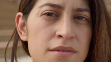 Ciddi bir yüzle kameraya bakan Latin bir kadının açık hava portresi. İnsan yüzüne yakın çekim. İnsanlar ve duygular kavramı.