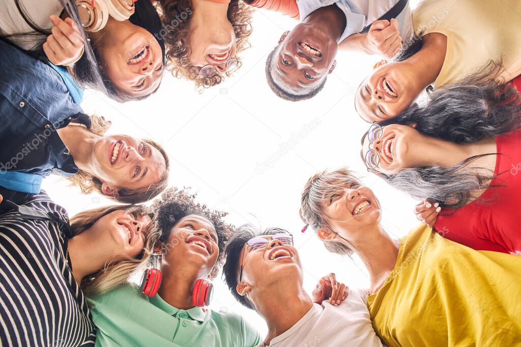 Low angle of a group of students are together, happy and smiling. Faces of young teenagers hugging.