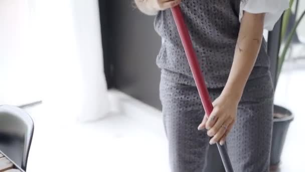 Grappig gek meisje dat danst met een bezem. Vrolijke schattige latina vrouw luisteren naar muziek plezier hebben tijdens het schoonmaken van haar huis. Echte mensen. — Stockvideo