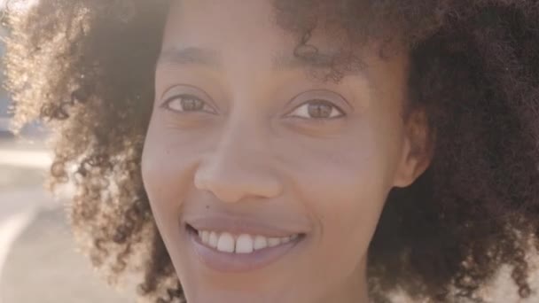 Retrato ao ar livre da mulher africana olhando para a câmera. Close-up de um rosto humano sorridente feliz. Conceito de pessoas e emoções. — Vídeo de Stock