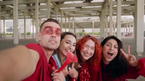 Selfie POV. Un grupo de amigos hacen una videollamada mientras animan a su equipo deportivo desde un estadio. Familia llamando para celebrar juntos en el estadio. — Vídeos de Stock