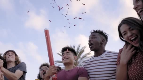 O movimento lento de um grupo internacional de jovens celebra com o confete do lado de fora. Conceito de celebração, festa, desfrutar, alegre. — Vídeo de Stock