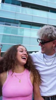 Dikey. Beş neşeli çoklu etnik öğrenci arkadaşlarını kaldırıyor, gülüyor ve parkta birlikte eğleniyorlar, boş zamanlarının ve arkadaşlıklarının tadını çıkarıyorlar.