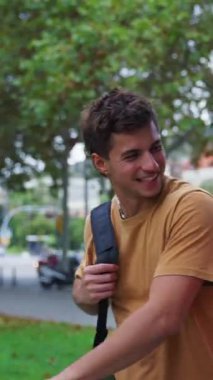 Dikey. Genç bir adam ve bir kadın, üniversite kampüsünde yürürken birbirlerini gülümseyerek selamlıyorlar. Dersten sonra arkadaşlarıyla güzel bir günün tadını çıkarıyorlar.