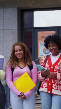 Dikey. Kampüs binasının merdivenlerinde gülen ve konuşan mutlu çok ırklı üniversite öğrencileri grubu, bir üniversite ortamında dostluk ve akademik yaşam tarzını gözler önüne seriyorlar.