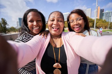Afrika 'da iki bin yıllık kızıyla birlikte gülümseyen Afrikalı bir anne şehirde neşeli bir selfie çekerken sevgi, çeşitlilik, aile bağı ve mutluluğu gösteriyor..