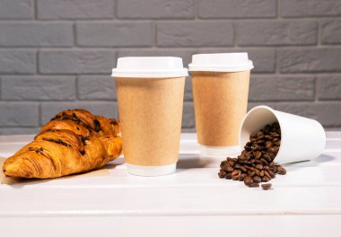 Kâğıt Eko Kupada Kahveyi Al ve Tahta Arkaplanda Çikolata ve Kahve Fasulyeli Taze Kruvasan