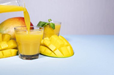 Mavi Arkaplanda Mango Shake. Sağlıklı İçici Vitamin Smoothie. Taze Tropik Mango Meyve Suyu. Metin ve Kopyalama için boşluk. Diyet Gıda. Renkli arka plan, Mükemmel sağlıklı vitamin öğle yemeği veya kahvaltı.