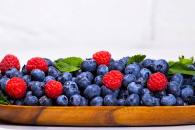 Beyaz manzaralı ahşap bir kasede yeşil nane yaprağı olan yabanmersini, Yaz Taze Berry, Copyspace.